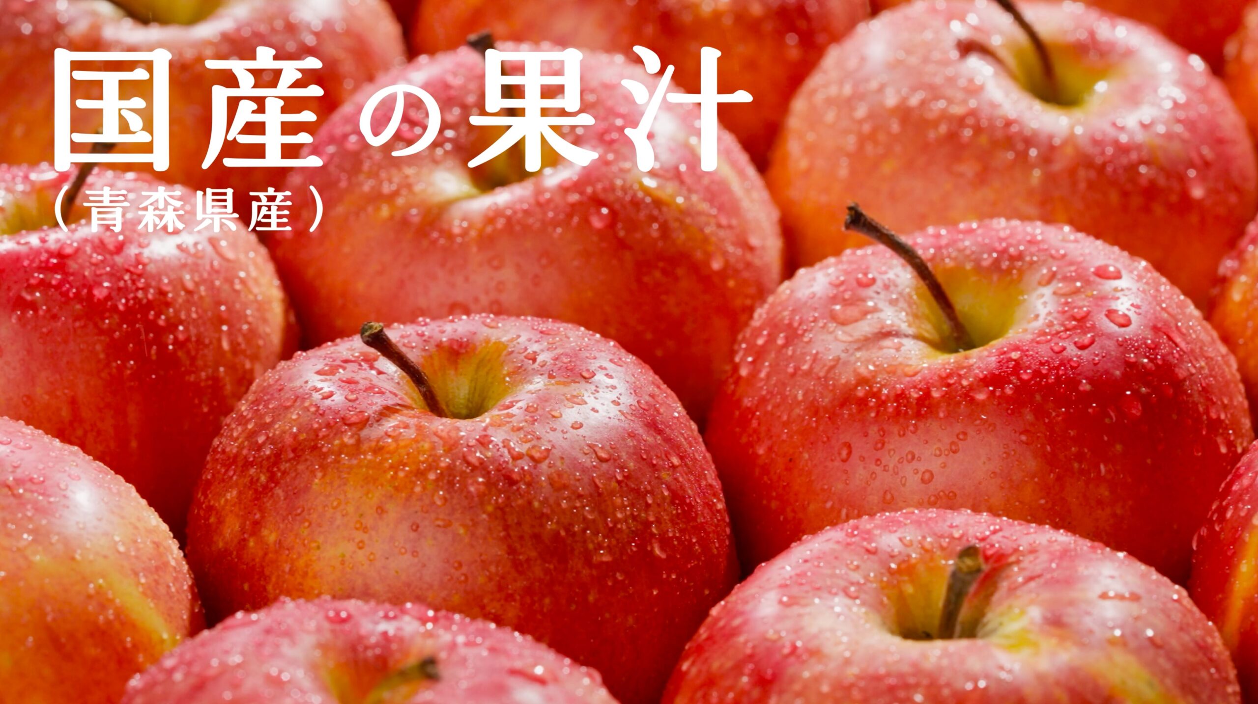 国産りんごの果汁感を伝える、水滴をまとった赤いりんご